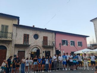 Nel fine settimana successivo alla riapertura del Palazzo Comunale e della Chiesa di San Francesco, simboli storici della città restaurati e restituiti alla cittadinanza il 4 luglio, Cascia ha proseguito le celebrazioni con due eventi centrati su giovani e sport, elementi fondanti del rinnovato spirito comunitario. Sabato pomeriggio, nella Limonaia di Palazzo Carli, recentemente oggetto di lavori di riqualificazione, si è svolta la cerimonia dedicata ai diplomati dell’anno scolastico 2024/25. La manifestazione, organizzata con la collaborazione della Consulta dei Giovani, ha inteso riconoscere l’impegno scolastico degli studenti locali, ma anche di coloro che, pur studiando fuori città, mantengono un forte legame con il territorio. Coinvolti anche gli studenti provenienti da altre zone, che hanno scelto gli istituti superiori casciani per il proprio percorso educativo. Alla guida dell’evento, il presidente della Consulta Omar Di Curzio e Giulia Emili, che ha curato gli aspetti organizzativi. Durante l’iniziativa, il sindaco Mario De Carolis ha sottolineato il valore dell’operato della Consulta, ricordando il recente riconoscimento espresso dalla presidente della Regione Umbria nel corso dell’inaugurazione istituzionale del giorno precedente. L’amministrazione comunale ha ribadito il ruolo centrale delle nuove generazioni nella costruzione del futuro della città. Tra i dati significativi emersi, anche il primo diploma ottenuto da un alunno della quinta classe dell’istituto alberghiero locale. L’assessore all’istruzione, Niccolò Sabatini, ha evidenziato come Cascia, nonostante la collocazione in area interna, sia riuscita a costruire un’offerta scolastica ampia e diversificata, capace di attrarre studenti anche da altre zone. Ha inoltre ringraziato gli studenti per l’impegno dimostrato, incoraggiandoli a mantenere vivo il legame con la propria terra d’origine, diventando promotori attivi della sua crescita. A rafforzare il senso istituzionale dell’iniziativa, è intervenuta anche la presidente del Consiglio comunale, Luisa Di Curzio, che si è congratulata con i diplomati e li ha invitati a considerare la sede comunale appena riaperta come luogo di appartenenza e partecipazione civica. Ha guidato personalmente una visita simbolica dei giovani alle stanze storiche di Palazzo Frenfanelli, arricchita da aneddoti e curiosità sulla storia del luogo. Anche il corpo docente ha partecipato alla cerimonia, rappresentato dalla professoressa Narducci e dalla professoressa Testaguzza. Entrambe hanno rimarcato l’importanza del percorso educativo come crescita non solo scolastica, ma anche personale, sottolineando l’evoluzione positiva dei rapporti tra scuola, studenti e territorio. La domenica ha poi visto la città riunirsi nuovamente in piazza per celebrare un altro traguardo significativo: la promozione in Serie B della Maia Volley Cascia. Una conquista sportiva che ha coinvolto tutta la cittadinanza, dalla prima squadra maschile al settore giovanile femminile, consolidando ulteriormente il legame tra attività sportive e coesione sociale. L’evento ha rappresentato non solo una festa per i risultati ottenuti, ma anche un riconoscimento al lavoro svolto da dirigenti, tecnici e atleti. Il sindaco ha voluto essere presente anche in questa occasione, portando i saluti dell’amministrazione comunale e congratulandosi con il presidente Daniele Marinelli, con la dirigenza e con tutti i protagonisti della stagione sportiva. Ha posto l’accento sul valore educativo della pallavolo, che ha saputo coinvolgere giovani e famiglie in un progetto condiviso di crescita e appartenenza. Con queste due giornate dense di significato, Cascia conferma la propria capacità di rigenerarsi attraverso la valorizzazione delle persone, delle relazioni e dei simboli della comunità. Un fine settimana che ha testimoniato l’energia di un territorio che, pur tra le sfide, continua a investire nella formazione, nella partecipazione e nello sport come strumenti fondamentali per costruire un futuro condiviso.