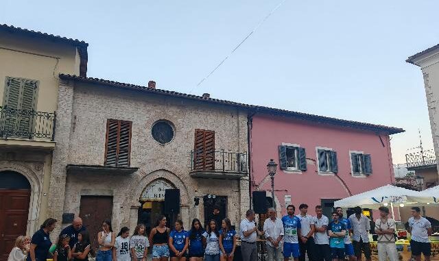 Nel fine settimana successivo alla riapertura del Palazzo Comunale e della Chiesa di San Francesco, simboli storici della città restaurati e restituiti alla cittadinanza il 4 luglio, Cascia ha proseguito le celebrazioni con due eventi centrati su giovani e sport, elementi fondanti del rinnovato spirito comunitario. Sabato pomeriggio, nella Limonaia di Palazzo Carli, recentemente oggetto di lavori di riqualificazione, si è svolta la cerimonia dedicata ai diplomati dell’anno scolastico 2024/25. La manifestazione, organizzata con la collaborazione della Consulta dei Giovani, ha inteso riconoscere l’impegno scolastico degli studenti locali, ma anche di coloro che, pur studiando fuori città, mantengono un forte legame con il territorio. Coinvolti anche gli studenti provenienti da altre zone, che hanno scelto gli istituti superiori casciani per il proprio percorso educativo. Alla guida dell’evento, il presidente della Consulta Omar Di Curzio e Giulia Emili, che ha curato gli aspetti organizzativi. Durante l’iniziativa, il sindaco Mario De Carolis ha sottolineato il valore dell’operato della Consulta, ricordando il recente riconoscimento espresso dalla presidente della Regione Umbria nel corso dell’inaugurazione istituzionale del giorno precedente. L’amministrazione comunale ha ribadito il ruolo centrale delle nuove generazioni nella costruzione del futuro della città. Tra i dati significativi emersi, anche il primo diploma ottenuto da un alunno della quinta classe dell’istituto alberghiero locale. L’assessore all’istruzione, Niccolò Sabatini, ha evidenziato come Cascia, nonostante la collocazione in area interna, sia riuscita a costruire un’offerta scolastica ampia e diversificata, capace di attrarre studenti anche da altre zone. Ha inoltre ringraziato gli studenti per l’impegno dimostrato, incoraggiandoli a mantenere vivo il legame con la propria terra d’origine, diventando promotori attivi della sua crescita. A rafforzare il senso istituzionale dell’iniziativa, è intervenuta anche la presidente del Consiglio comunale, Luisa Di Curzio, che si è congratulata con i diplomati e li ha invitati a considerare la sede comunale appena riaperta come luogo di appartenenza e partecipazione civica. Ha guidato personalmente una visita simbolica dei giovani alle stanze storiche di Palazzo Frenfanelli, arricchita da aneddoti e curiosità sulla storia del luogo. Anche il corpo docente ha partecipato alla cerimonia, rappresentato dalla professoressa Narducci e dalla professoressa Testaguzza. Entrambe hanno rimarcato l’importanza del percorso educativo come crescita non solo scolastica, ma anche personale, sottolineando l’evoluzione positiva dei rapporti tra scuola, studenti e territorio. La domenica ha poi visto la città riunirsi nuovamente in piazza per celebrare un altro traguardo significativo: la promozione in Serie B della Maia Volley Cascia. Una conquista sportiva che ha coinvolto tutta la cittadinanza, dalla prima squadra maschile al settore giovanile femminile, consolidando ulteriormente il legame tra attività sportive e coesione sociale. L’evento ha rappresentato non solo una festa per i risultati ottenuti, ma anche un riconoscimento al lavoro svolto da dirigenti, tecnici e atleti. Il sindaco ha voluto essere presente anche in questa occasione, portando i saluti dell’amministrazione comunale e congratulandosi con il presidente Daniele Marinelli, con la dirigenza e con tutti i protagonisti della stagione sportiva. Ha posto l’accento sul valore educativo della pallavolo, che ha saputo coinvolgere giovani e famiglie in un progetto condiviso di crescita e appartenenza. Con queste due giornate dense di significato, Cascia conferma la propria capacità di rigenerarsi attraverso la valorizzazione delle persone, delle relazioni e dei simboli della comunità. Un fine settimana che ha testimoniato l’energia di un territorio che, pur tra le sfide, continua a investire nella formazione, nella partecipazione e nello sport come strumenti fondamentali per costruire un futuro condiviso.